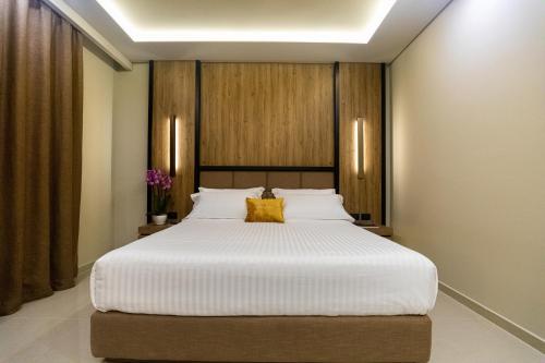 a bedroom with a large white bed with yellow pillows at Kraal Hotel Vlore in Vlorë