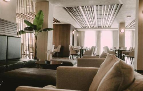 a hotel lobby with couches and tables and chairs at Apolon Spa in Vrnjačka Banja