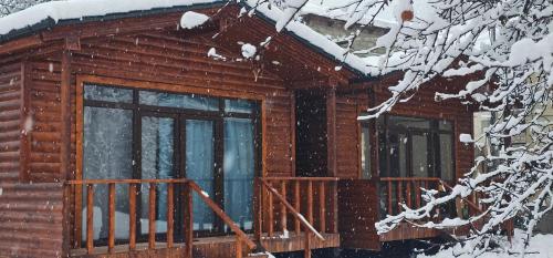 a log cabin in the snow with a deck at Cottage Talu in Mestia in Mestia