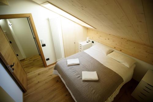 Un dormitorio con una cama con dos toallas encima. en A93A Apartment Alicia, en Carano