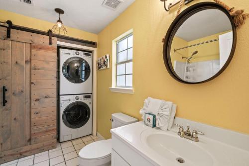 y baño con lavadora y espejo. en Blues Beach Bungalow, en Navarre