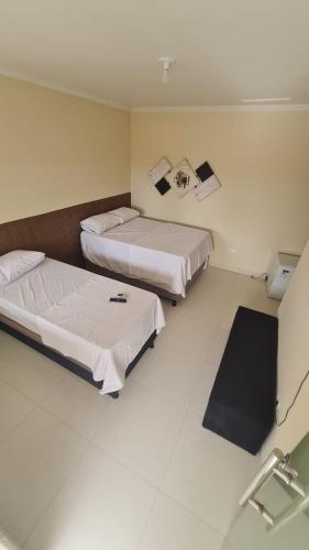 a hotel room with two beds and a mirror at Casa de temporada em Prado-BA in Prado