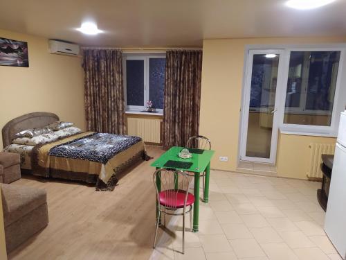 a bedroom with a bed and a green table at Центр район 5 школи Апартаменти in Poltava