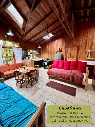 a living room with a red couch and a table at Los Quetzales Ecolodge & Spa in Cerro Punta