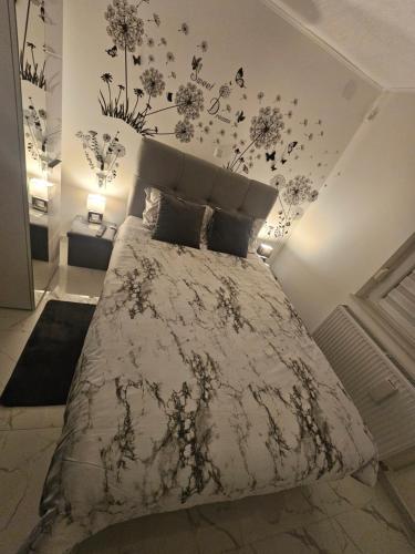 a bedroom with a bed with flowers on the wall at ENA 1&2 -BIG FREE PRIVAT parking for BOATS, TRUCKs, combi,-CENTRAL HEATING !!! in Karlovac