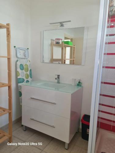 a bathroom with a white sink and a mirror at Maison accueillante à Anse-Bertrand avec jardin privé 70 m² in Anse-Bertrand