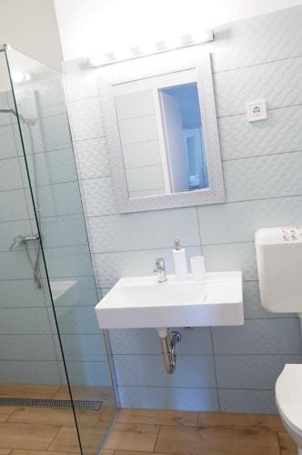 a bathroom with a sink and a mirror at Pécs Centrum Apartman in Pécs