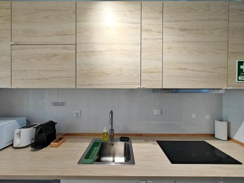 a kitchen with a sink and wooden cabinets at Carnide 1913 D - 1BR apt in Lisbon