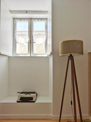 a room with a window and a keyboard and a lamp at Carnide 1913 D - 1BR apt in Lisbon