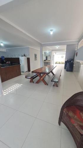 a large living room with a wooden table and bench at Casa de temporada em Prado-BA in Prado