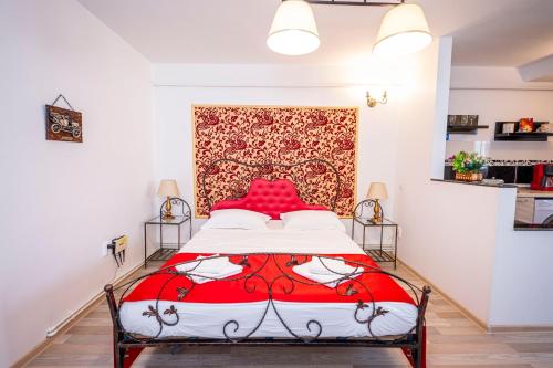 a bedroom with a red bed with a red headboard at Studio Clasic in Galaţi