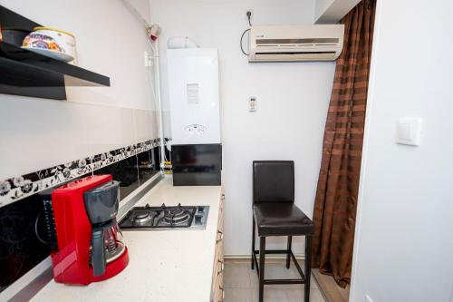 a small kitchen with a stove and a chair at Studio Clasic in Galaţi