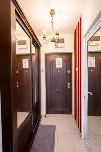 a hallway with two brown doors and a chandelier at Studio Clasic in Galaţi