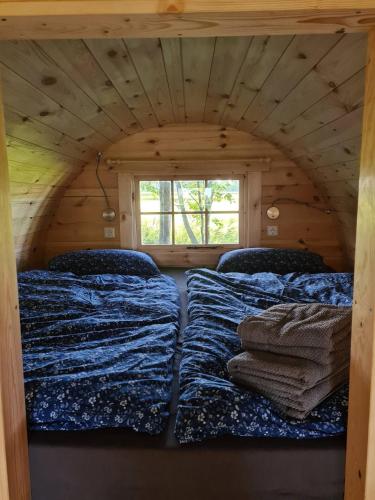 a room with two beds in a log cabin at Schlaffässer in der Natur in Holtgast