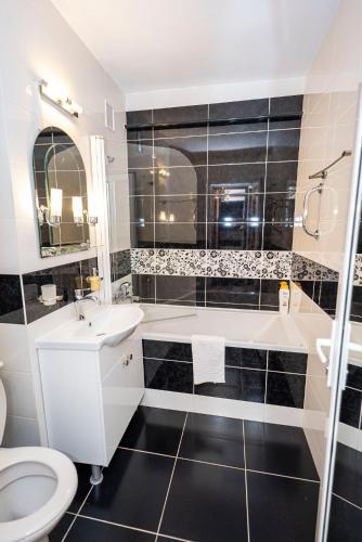 a bathroom with a tub and a sink and a toilet at Studio Clasic in Galaţi