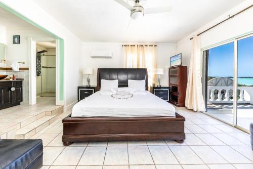 a bedroom with a bed and a view of the ocean at Waterside Home, Shaded Whirlpool Spa, Outdoor Dining, Smart TV, Amazon Prime in Providenciales