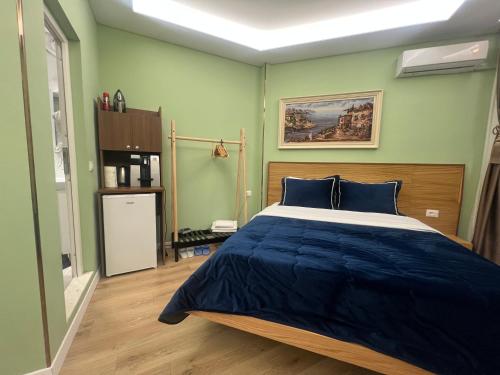 a bedroom with a large bed with blue sheets at Spiranca Luxury Suites in Tirana