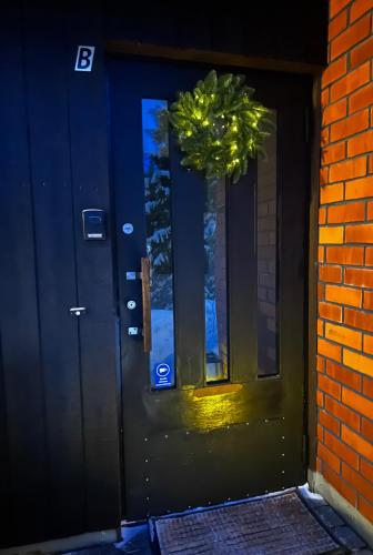 een blauwe deur met een krans erop bij Kaksio paritalossa in Mikkeli