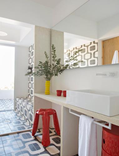 a bathroom with a white counter and a red stool at Villa Extramuros in Arraiolos