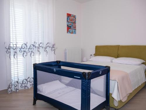 a blue crib in a room with a bed at Vista Capo d'Orlando in Capo dʼOrlando