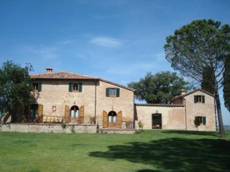 a large stone house in a field of grass at Al Giardino Degli Etruschi in Chiusi