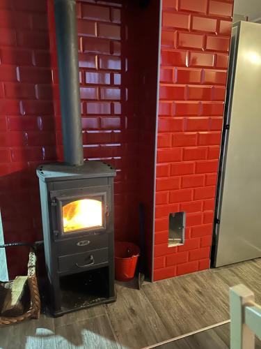 a stove in a room with a red brick wall at Mazury Dom Oskar nad jeziorem Sasek Wielki z jakuzzi in Szczytno