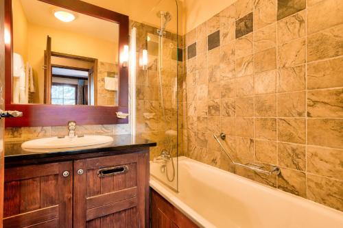 une salle de bain avec un lavabo, une baignoire et une douche dans l'établissement Résidence Les Arcs 1950 Le Village - maeva Home - Appartement 3 pièces 6 personnes - Sélection MAE-8281, à Arc 1950