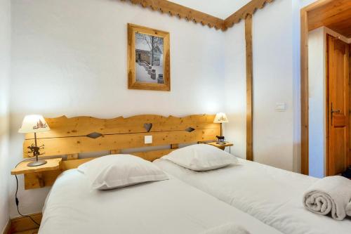 - une chambre avec 2 lits et une tête de lit en bois dans l'établissement Résidence Le Roselend - maeva Home - Appartement 3 pièces 6 personnes - Sélection MAE-9221, à Bourg-Saint-Maurice