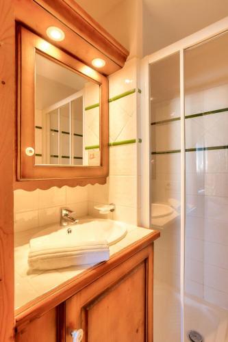 une salle de bain avec un lavabo, un miroir et une douche dans l'établissement Résidence Le Roselend - maeva Home - Appartement 3 pièces 6 personnes - Sélection MAE-9221, à Bourg-Saint-Maurice