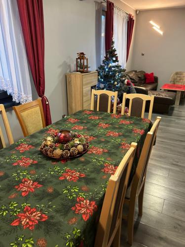 a christmas table with a christmas tree in a room at Mazury Dom Oskar nad jeziorem Sasek Wielki z jakuzzi in Szczytno