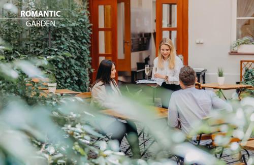 a group of people sitting at a table at Hotel Adler - Czech Leading Hotels in Prague
