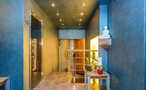 a room with blue walls and a staircase with a table at Albergo Celide in Lucca