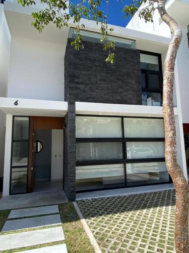 a white house with a door and a tree at Villa Roma in Akumal