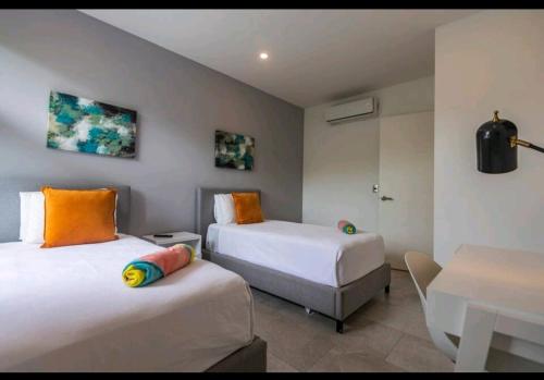 a room with two beds and a table and a desk at Villa Roma in Akumal