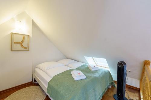 Maisonette am Holstentor mit Dachterrasse und Heimkino في لوبيك: غرفة نوم صغيرة مع سرير في العلية