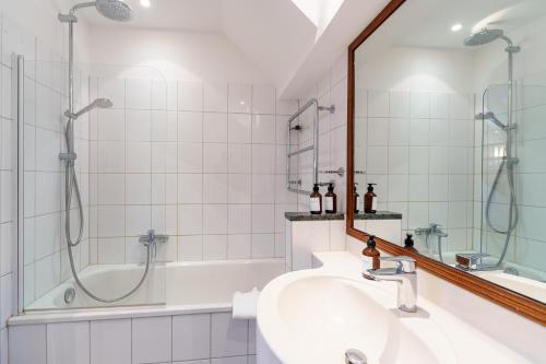 Maisonette am Holstentor mit Dachterrasse und Heimkino في لوبيك: حمام مع دش ومغسلة وحوض استحمام