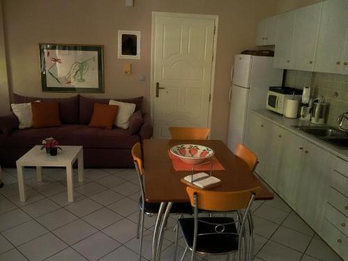 a living room with a table and a kitchen at Το Κουκλάκι της Παναγιώτας - Panagiota's Dollhouse in Paralion astros