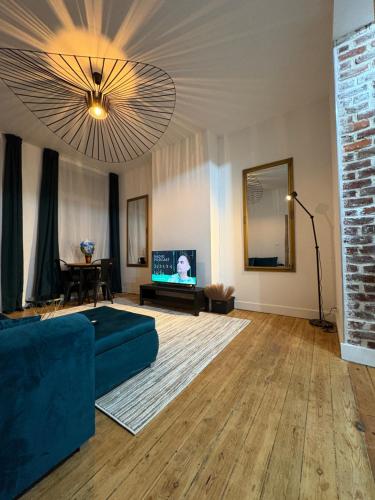 a living room with a blue couch and a television at Echoes of the Mirror in Brussels