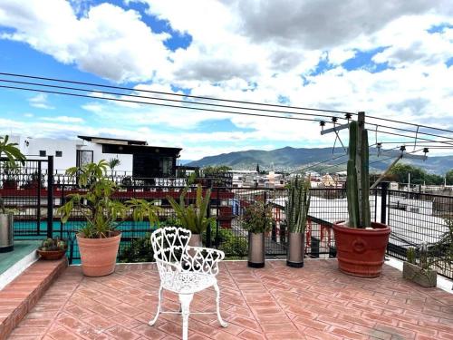 a patio with two chairs and plants on a balcony at Casa matamoros in Oaxaca City