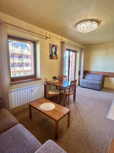 a living room with a table and a couch at Holiday Resort Tatry in Veľká Lomnica