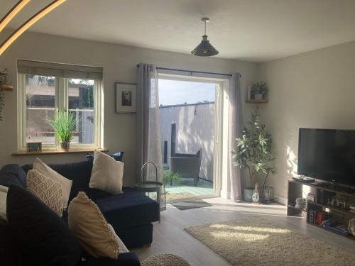 a living room with a blue couch and a window at Pebble Cottage in Hunstanton