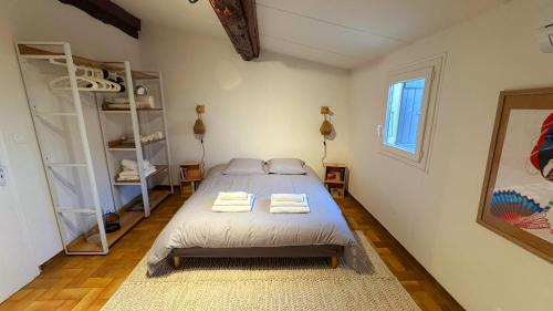 une chambre avec un lit avec deux serviettes dessus dans l'établissement La Parenthèse Piscénoise, à Pézenas