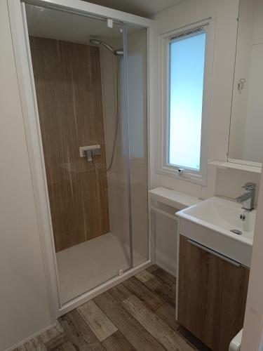 une salle de bain avec douche et lavabo dans l'établissement Camping mer et soleil, à Saint-Georges-dʼOléron
