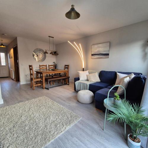 a living room with a blue couch and a table at Pebble Cottage in Hunstanton