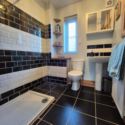 a bathroom with a toilet and a sink and a tub at Pebble Cottage in Hunstanton