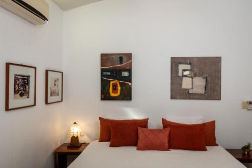 a bedroom with a bed and some paintings on the wall at Hotel Villa Mozart y Macondo in Puerto Escondido