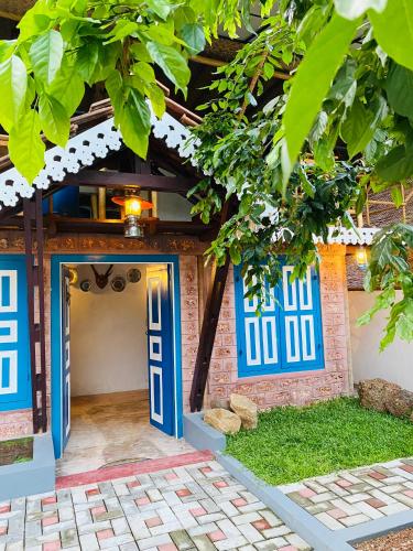 an entrance to a house with blue doors at Airport Accommodation in Maduwa