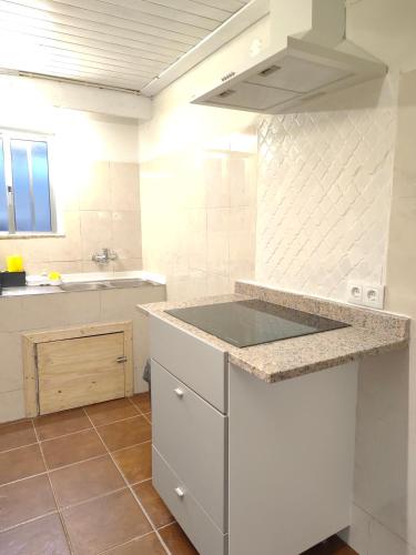 a white kitchen with a counter and a sink at Vale Das 7Lagoas in Geres