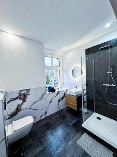 a bathroom with a shower and a toilet and a sink at Villa Baumhaus Apartments in Hamm