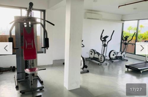 a gym with cardio equipment and a woman on a treadmill at Diplomat Suites at Heights Residencies in Narahenpita